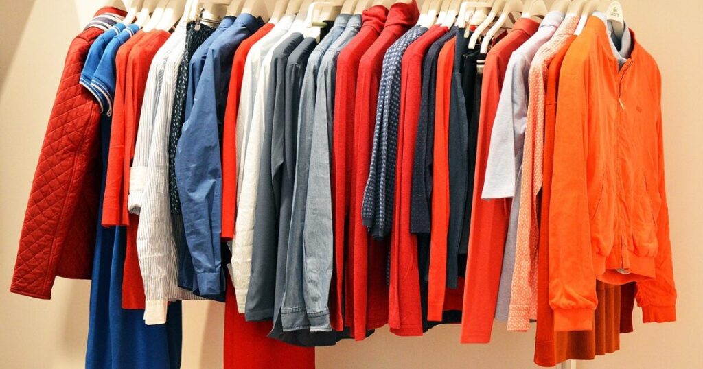 赤と青を基調とした洋服が並ぶハンガーラック