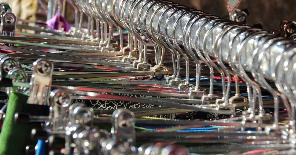 金属製ハンガーが密集して並ぶ洋服売り場