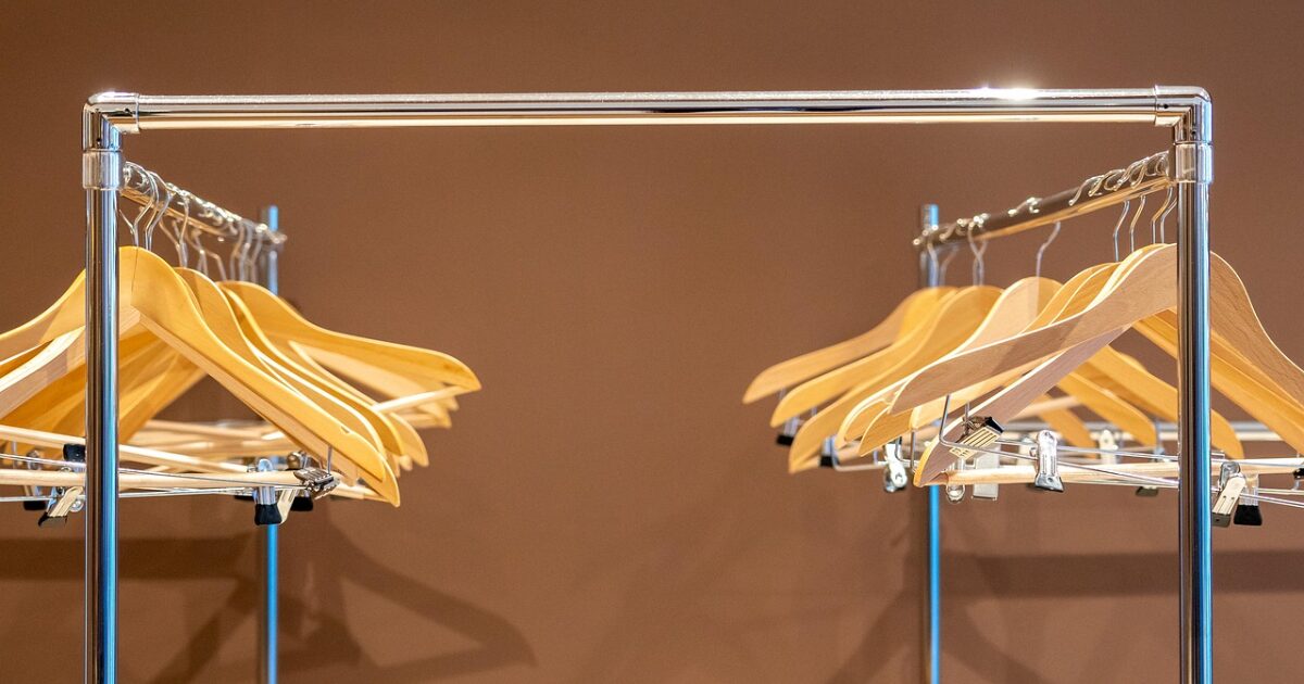 空の木製ハンガーが並ぶクロームラック