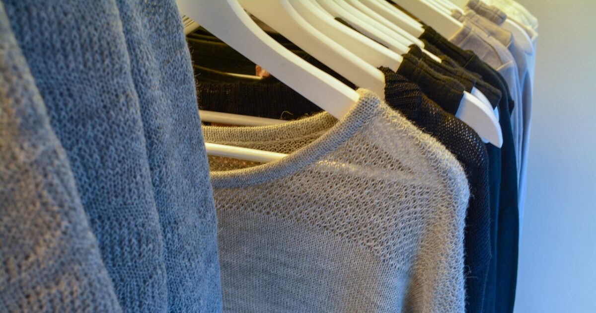 ブルー系ニットが白いハンガーにかかったクローズアップ