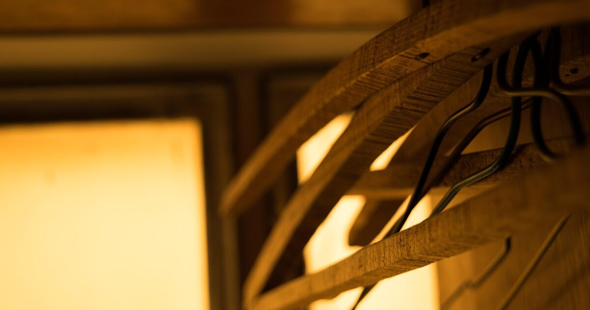 暖色の照明に照らされた空の木製ハンガー