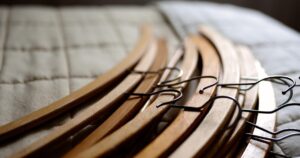 布団の上に重ねられた木製ハンガー